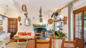 A cozy living room with a fireplace, wooden furniture, and a dining area. - Country House 'La Rana Verde De Arriba' with Mountain Views, Private Terrace & Wi-Fi (Los Romeros)