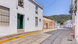 A cobblestone street lined with white buildings, a green door, and a yellow curb. - Country House 'La Rana Verde De Arriba' with Mountain Views, Private Terrace & Wi-Fi (Los Romeros)