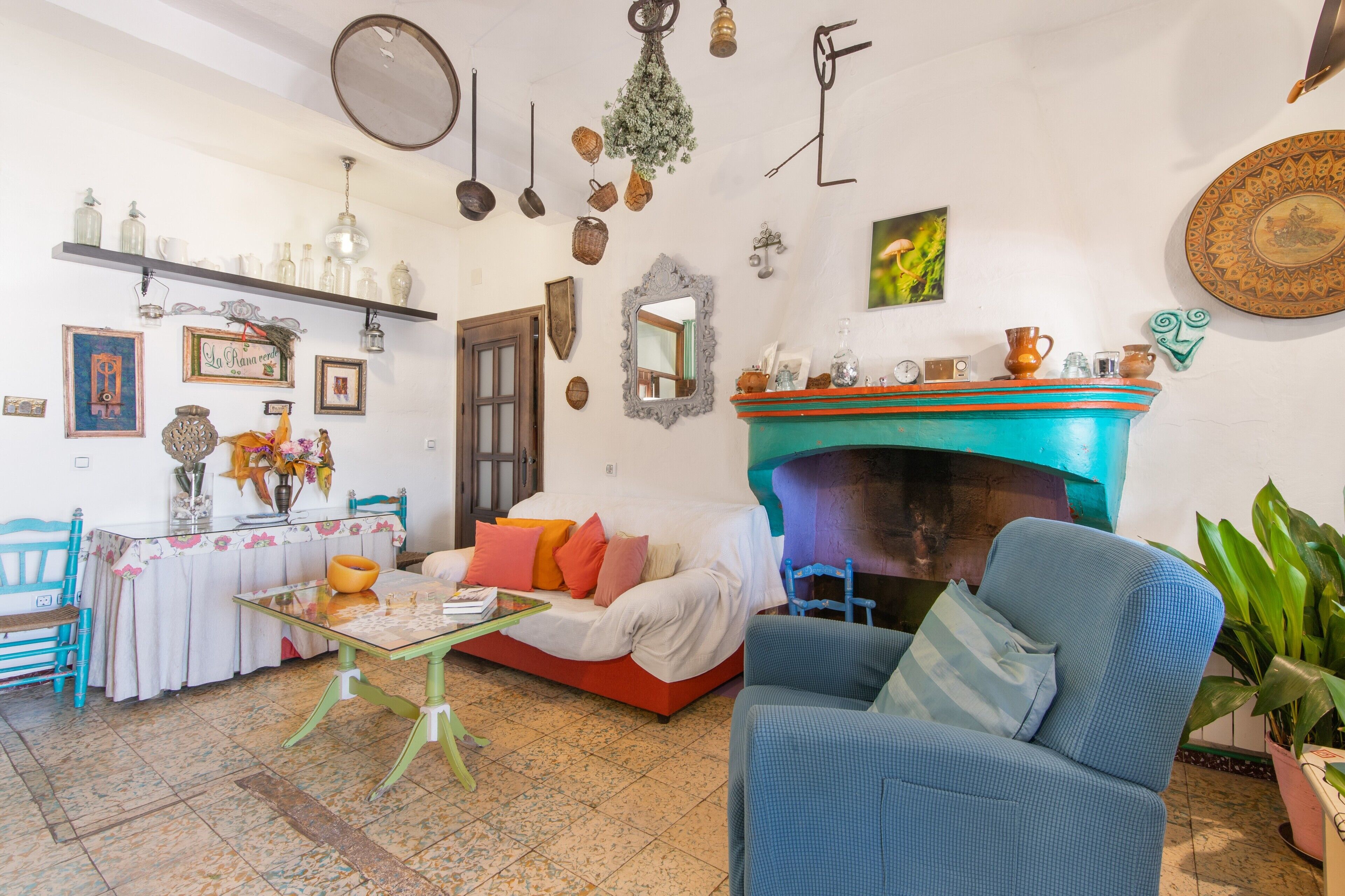 A cozy living room with a fireplace, a sofa, a table, and various decorative items.