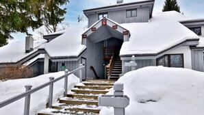 A snow-covered staircase leading to a building with a Village Center sign.