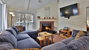 A living room with a fireplace, a television, and a sofa.