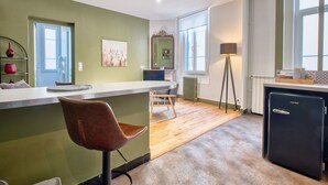Une cuisine équipée d’un coin bar, d’un réfrigérateur et d’une chaise.