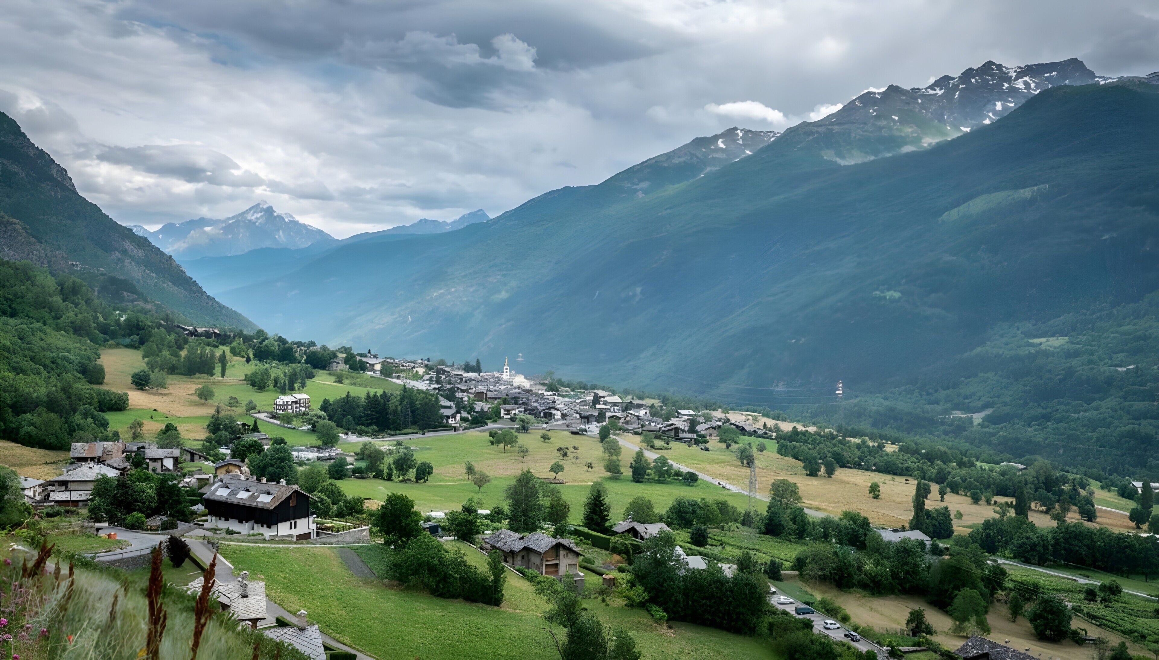 Ein dorf in den Bergen mit traditionellen Häusern, einer Kirche und freiem Blick ins Tal.