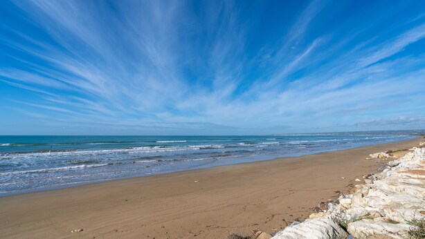 Ein Strand mit blauem Himmel und Wellen.