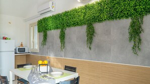 Comedor con una mesa dispuesta para dos personas, microondas y refrigerador.