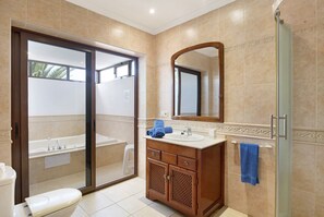A bathroom with a toilet, sink, and shower.