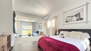 Une chambre moderne avec un grand lit, un bureau et une fenêtre avec des rideaux.