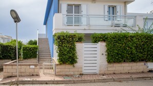 A two-story building with a balcony, a gate, and a staircase leading to the entrance. - Apartment 'Ammari' with Private Terrace, Balcony and Air Conditioning (Marina di Ragusa)