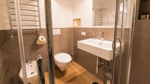 Une salle de bain moderne avec une douche à parois de verre, un lavabo blanc et des toilettes.