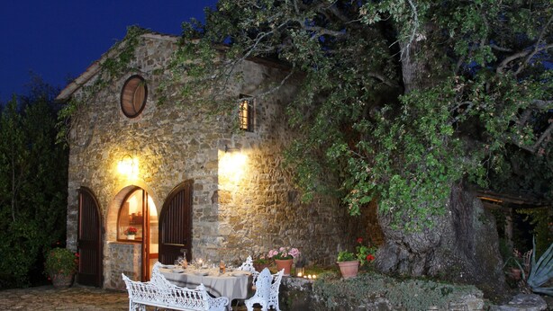 A stone building with arched doorways and a table set for dining, surrounded by greenery. - Holiday Home 'Chianti Loft' with Mountain View, Wi-Fi and Air Conditioning (Greve in Chianti)