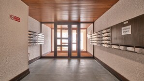 A hallway with a wooden ceiling, a fire safety sign, and a wall with labeled storage units.