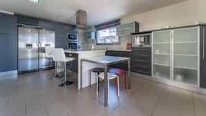 Een moderne keuken met roestvrijstalen apparatuur, een centraal kookeiland en een raam.