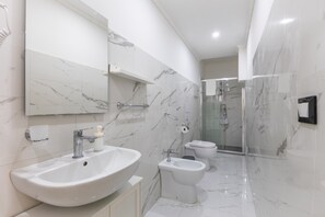 A modern bathroom with a large sink, bidet, toilet, and a glass shower enclosure. - Apartment 'Stella Marina' with Shared Pool, Wi-Fi and Air Conditioning (Pachino)