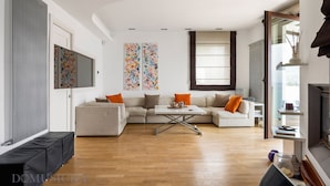 A modern living room with a sofa set, a coffee table, and artwork on the walls.