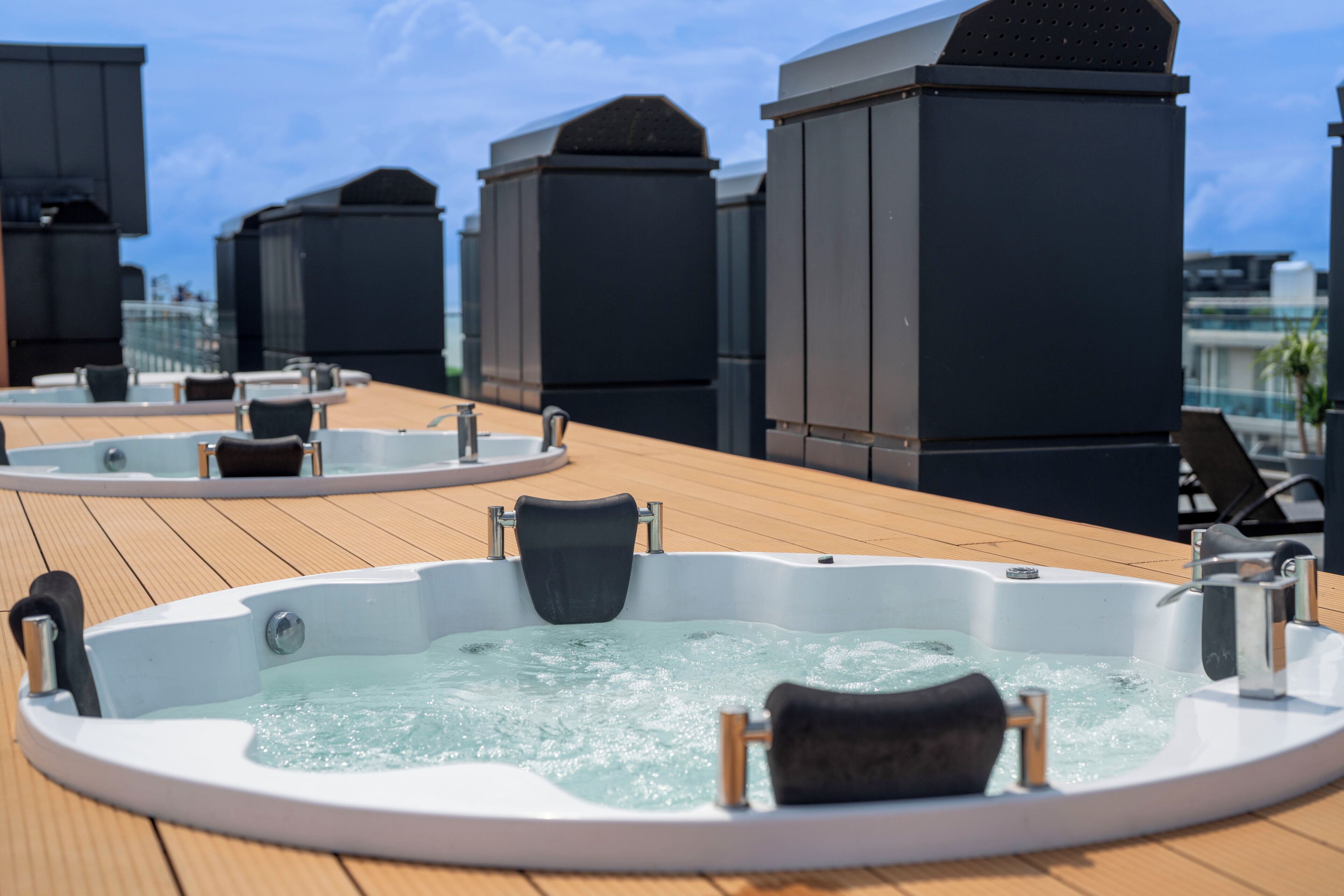 Terraza en la azotea con varios jacuzzis y zonas de estar.