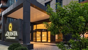 The exterior of La Quinta by Wyndham hotel with a modern design, a revolving door entrance, and a well-lit facade. - La Quinta by Wyndham Batumi (Batumi)