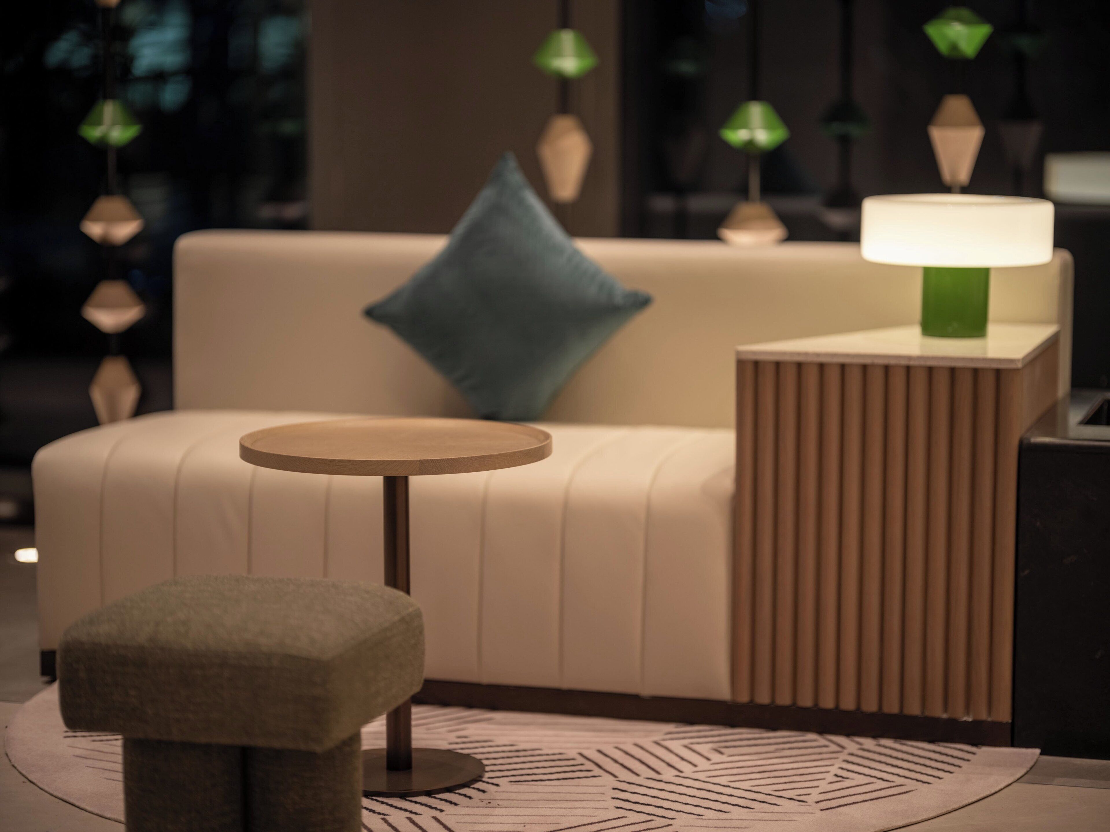Ein modernes Wohnzimmer mit einer Couch, einem runden Tisch und einer Lampe.