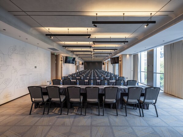 A conference room with a long table, chairs, and a large screen. - EVEN Hotel Shanghai Jinqiao by IHG (Shanghai)