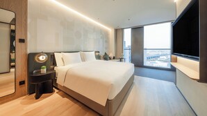 A modern hotel room with a large bed, a bedside table with a lamp, a TV mounted on the wall, and a city view through the window. - EVEN Hotel Shanghai Jinqiao by IHG (Shanghai)