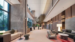 A spacious lobby with a high ceiling, marble walls, and a central seating area with sofas and a coffee table. - EVEN Hotel Shanghai Jinqiao by IHG (Shanghai)