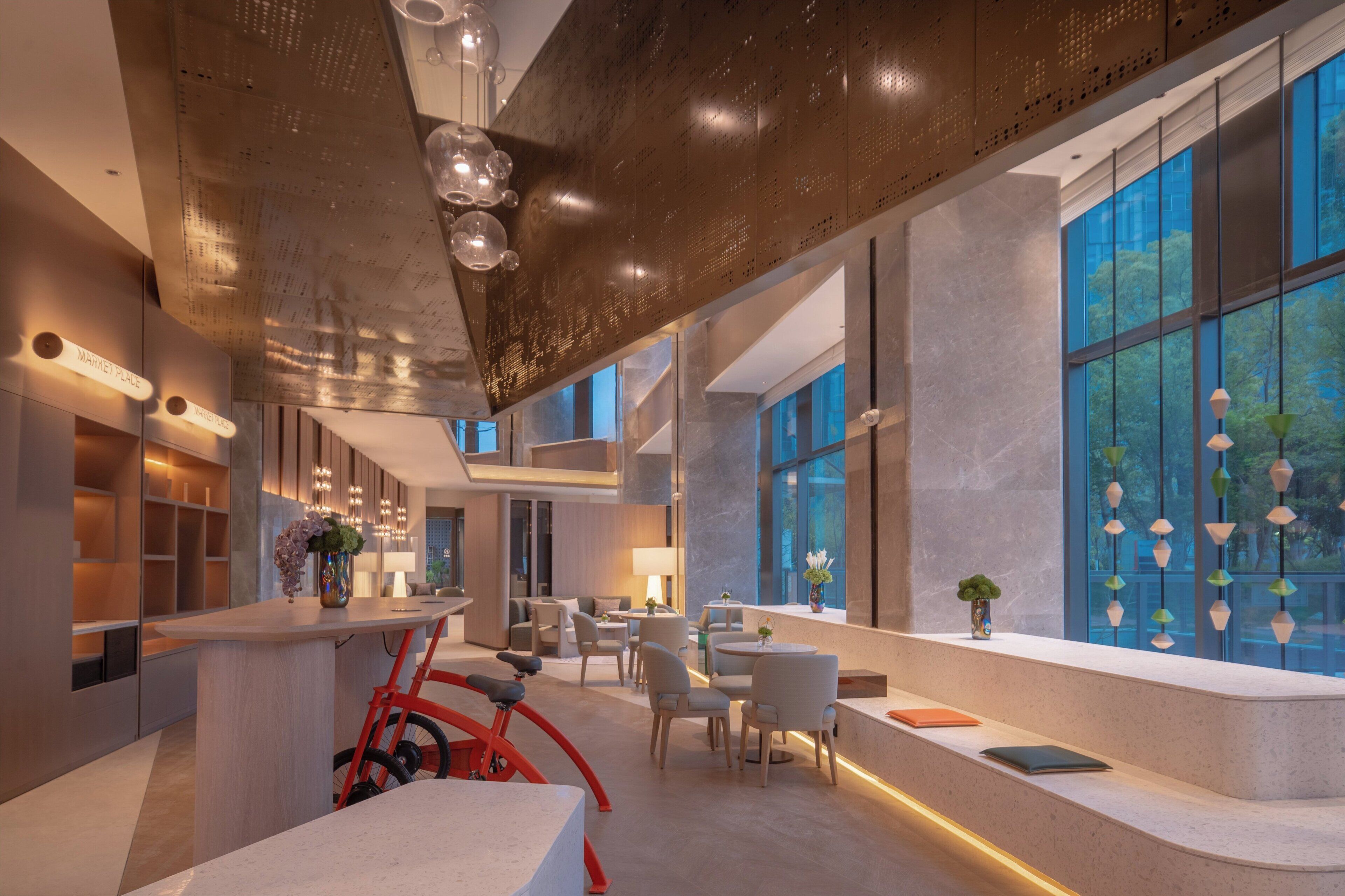 A modern interior with a reception desk, seating area, and large windows.