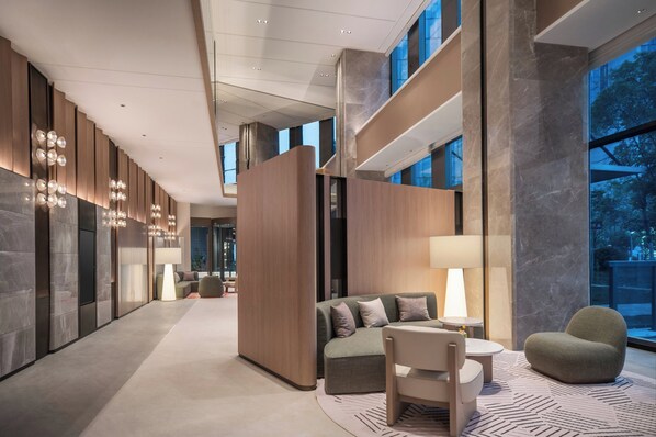A modern hotel lobby with a sofa, chairs, and a lamp. - EVEN Hotel Shanghai Jinqiao by IHG (Shanghai)