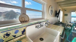 A bathroom with a large window, a sink, and a mirror.
