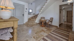 A spacious living area with a marble floor, a wooden table with a lamp, a staircase, and a small round table with chairs. - Jardin d'Uzès walking distance village (Saint-Quentin-la-Poterie)