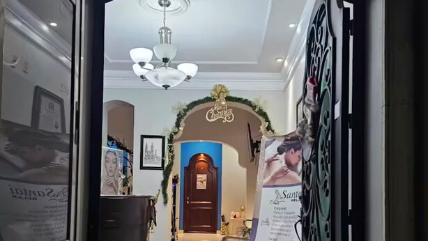 A hotel reception area with a modern design, including a reception desk, a blue door, and a chandelier. - Casa Real Hotel (Degollado)