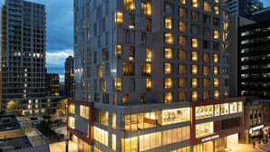 A modern hotel with a glass facade, multiple floors, and a prominent entrance. - AC Hotel BY Marriott Ottawa Dwtn (OTTAWA)