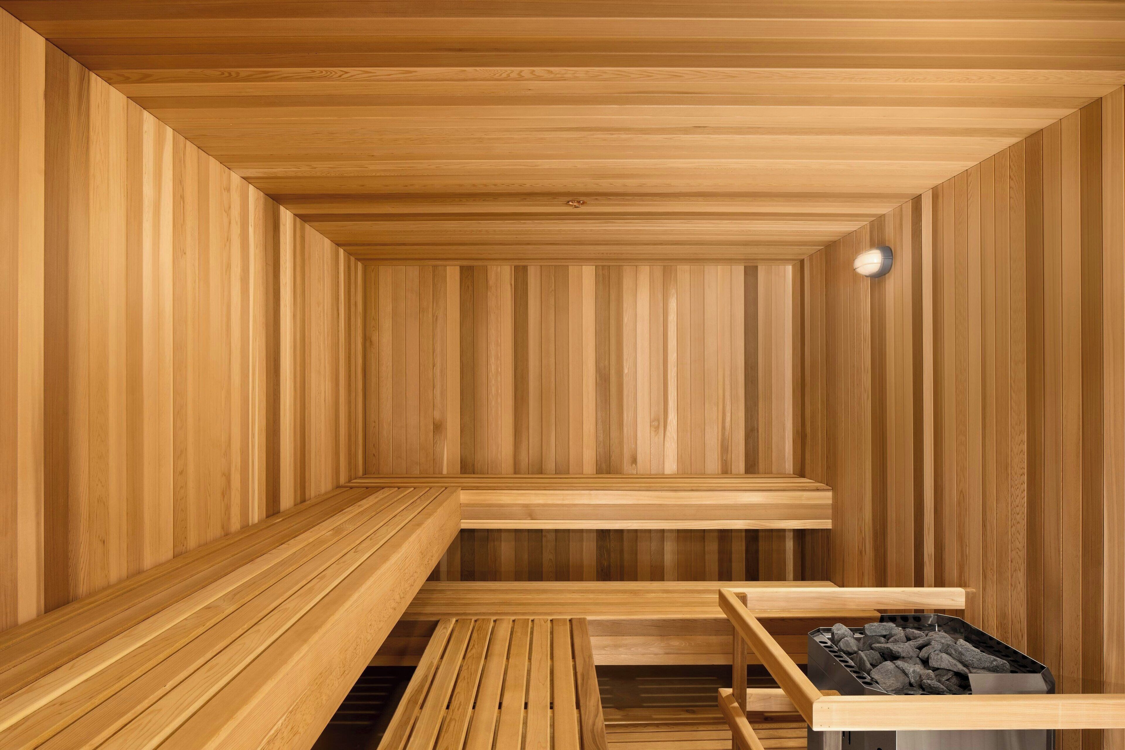 A sauna with wooden benches and a bench with a charcoal container.