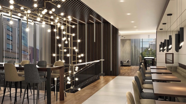A modern interior with a staircase, dining area, and seating. - AC Hotel BY Marriott Ottawa Dwtn (OTTAWA)