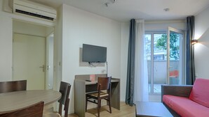 A compact living space with a dining area, a work desk, a sofa, and a television. - À 3 km de la gare RER E | Accès rapide à Paris (Nogent-sur-Marne)