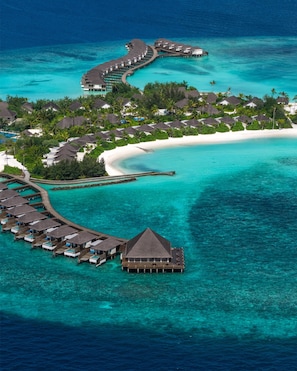 An aerial view of a resort with overwater bungalows, a beach, and clear turquoise waters. - dusitD2 Feydhoo Maldives (Feydhoofinolhu)