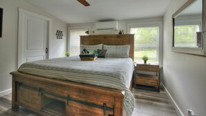 A bedroom with a wooden bed, a ceiling fan, a nightstand, and a window with blinds. - Spacious 3BR Family Home  Pet Friendly  Private Yard 20 Min to Disney (Davenport)