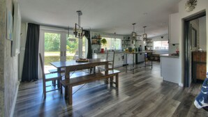 A spacious kitchen with a dining area, wooden flooring, and large windows. - Spacious 3BR Family Home  Pet Friendly  Private Yard 20 Min to Disney (Davenport)