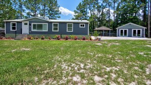 A two-story house with a front porch, a covered patio, and a small shed. - Spacious 3BR Family Home  Pet Friendly  Private Yard 20 Min to Disney (Davenport)