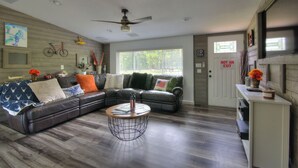 A living room with a sectional sofa, a coffee table, and a ceiling fan. - Spacious 3BR Family Home  Pet Friendly  Private Yard 20 Min to Disney (Davenport)