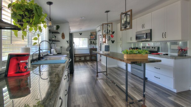 A modern kitchen with white cabinets, stainless steel appliances, and a wooden countertop. - Spacious 3BR Family Home  Pet Friendly  Private Yard 20 Min to Disney (Davenport)