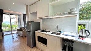 Une cuisine moderne équipée d’un réfrigérateur, d’une cuisinière, d’un évier et d’une fenêtre donnant sur un paysage verdoyant.