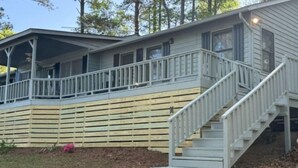 A two-story house with a covered porch and a staircase leading to the upper level.