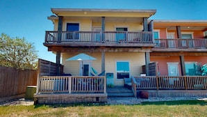 A two-story building with a balcony on the ground floor and a second-floor balcony.