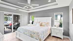 Una camera da letto con un letto, un comodino, una ventola a soffitto e una finestra vista all'esterno.