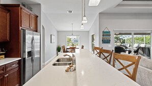 Una cucina moderna con isola centrale, elettrodomestici in acciaio inossidabile e mobili in legno.