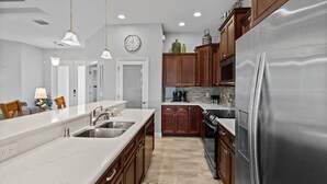 Una cucina moderna con frigorifero in acciaio inossidabile, un lavello doppio e mobili in legno.