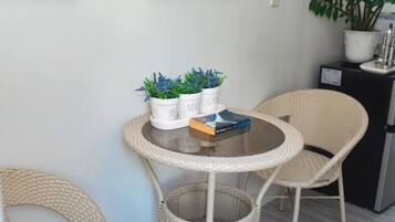 A round table with a book and three potted plants.