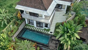 A two-story house with a swimming pool, surrounded by lush greenery. - Umah Kemuning Near Central Ubud Bali (Bali)