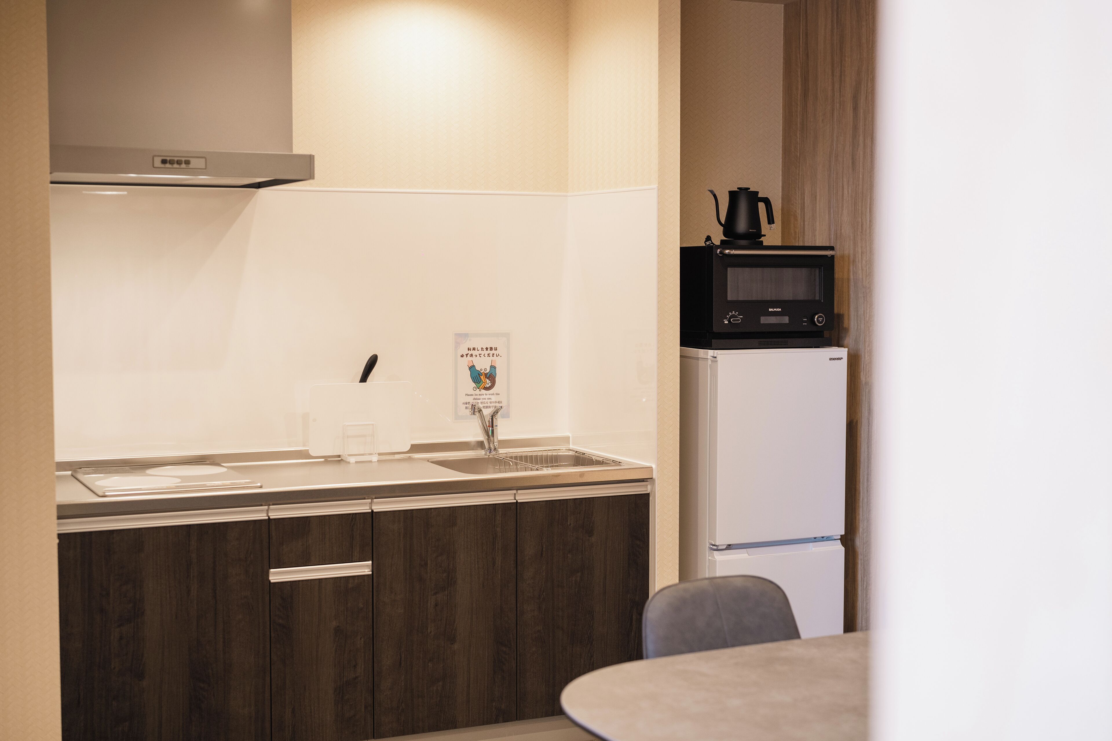 A compact kitchen with a microwave, refrigerator, and a small sink.