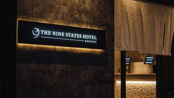 Ein Schild für das Hotel 'The Nine States Hotel' mit modernem Design und beleuchteter Schrift.