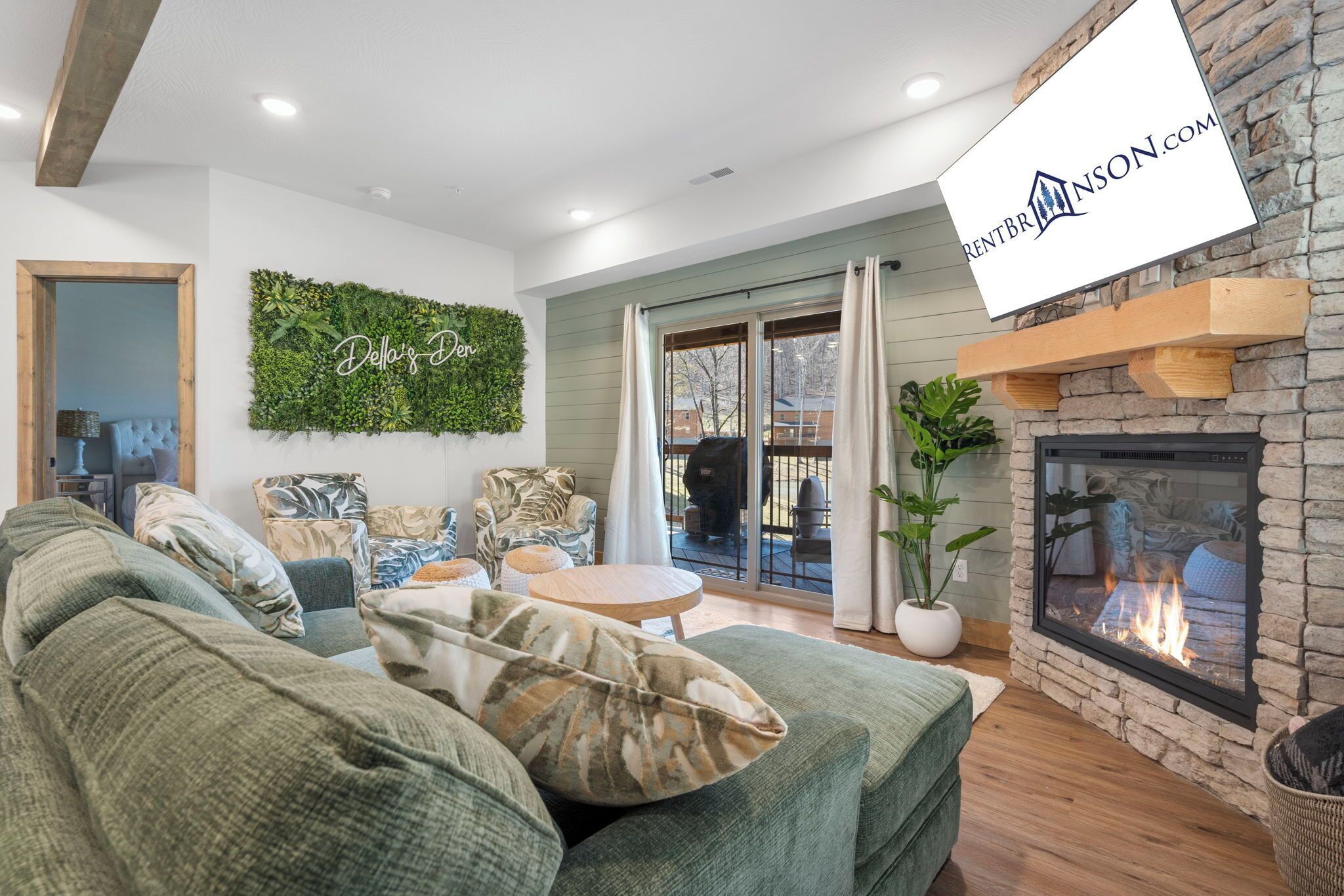 Un salon chaleureux avec un canapé vert, une cheminée et un décor mural vert.